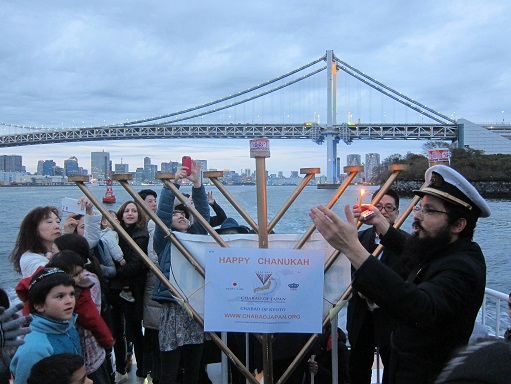 Chabad Japan lights menorah under Rainbow Birdge